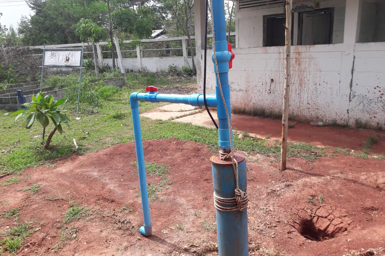Revestimento de poço com tubulação azul saindo do solo em quintal, local da instalação de bomba de poço artesiano no Rio de Janeiro